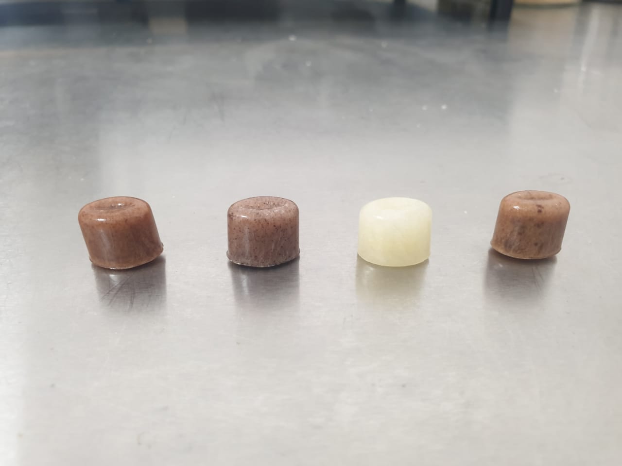 Four real TTL lozenges photographed on a stainless-steel counter